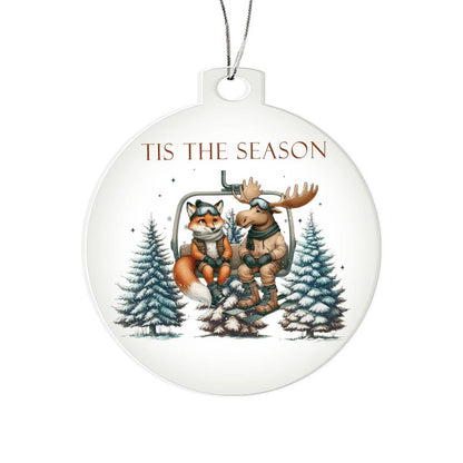 Acrylic Christmas ornament featuring a fox and moose on a ski lift with the words "Tis The Season."
