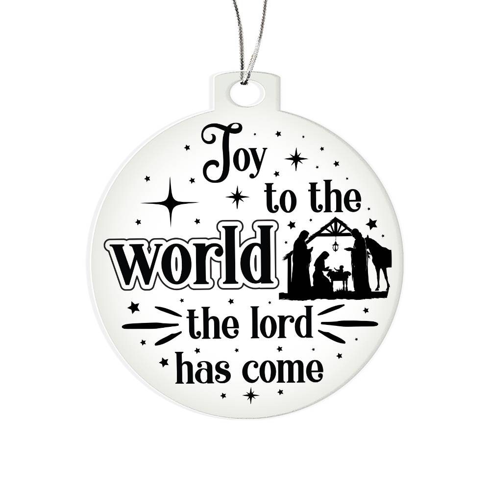 Clear Christmas ornament with nativity scene and "Joy to the World" text.
