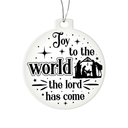 Clear Christmas ornament with nativity scene and "Joy to the World" text.
