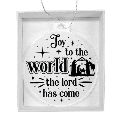 Clear Christmas ornament with nativity scene and "Joy to the World" text.
