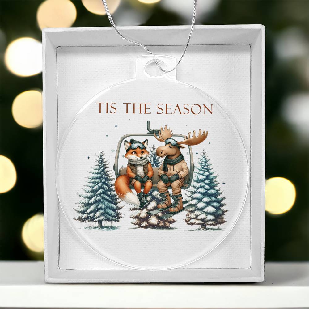 Acrylic Christmas ornament featuring a fox and moose on a ski lift with the words "Tis The Season."
