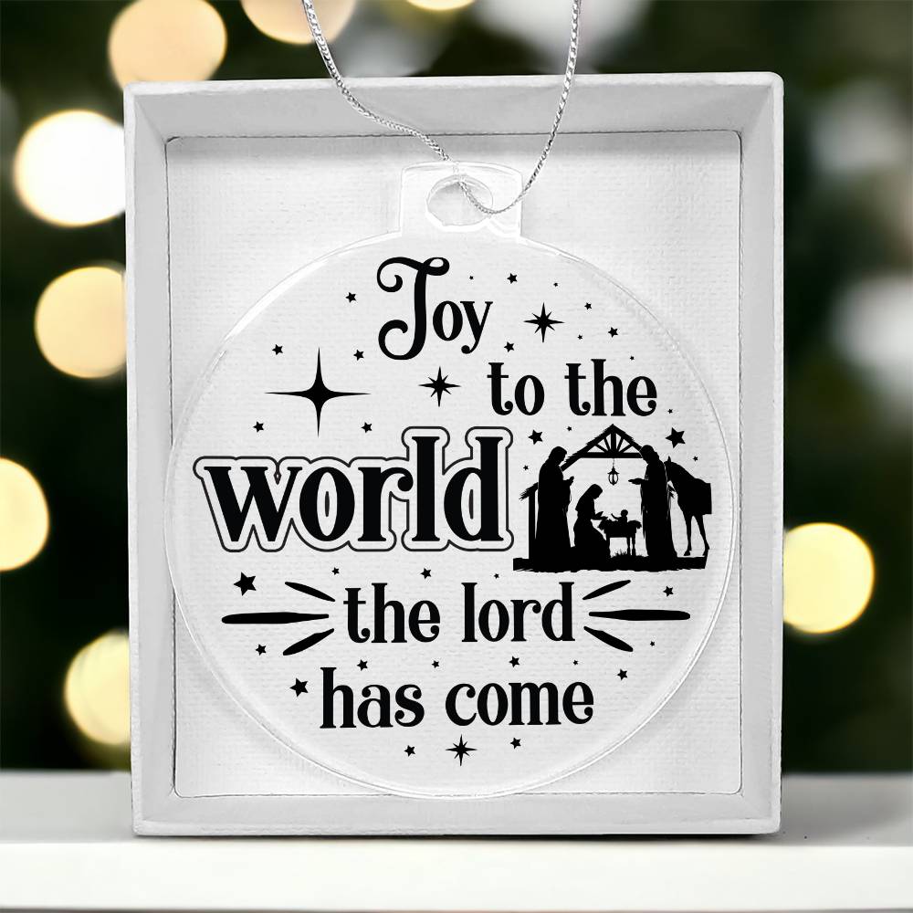 Clear Christmas ornament with nativity scene and "Joy to the World" text.
