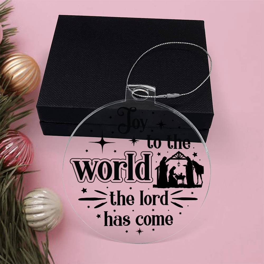 Clear Christmas ornament with nativity scene and "Joy to the World" text.
