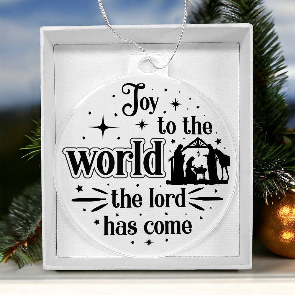 Clear Christmas ornament with nativity scene and "Joy to the World" text.
